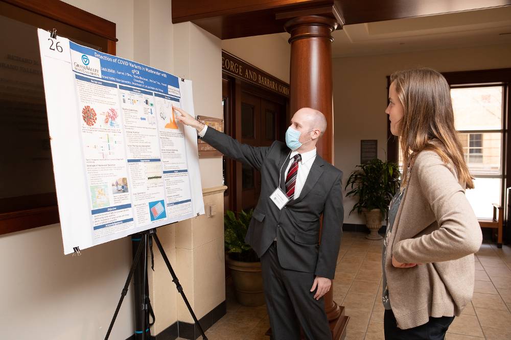 Louis Walter discussing his poster with Graduate Assistant to The Graduate School, Maggie Scannell.